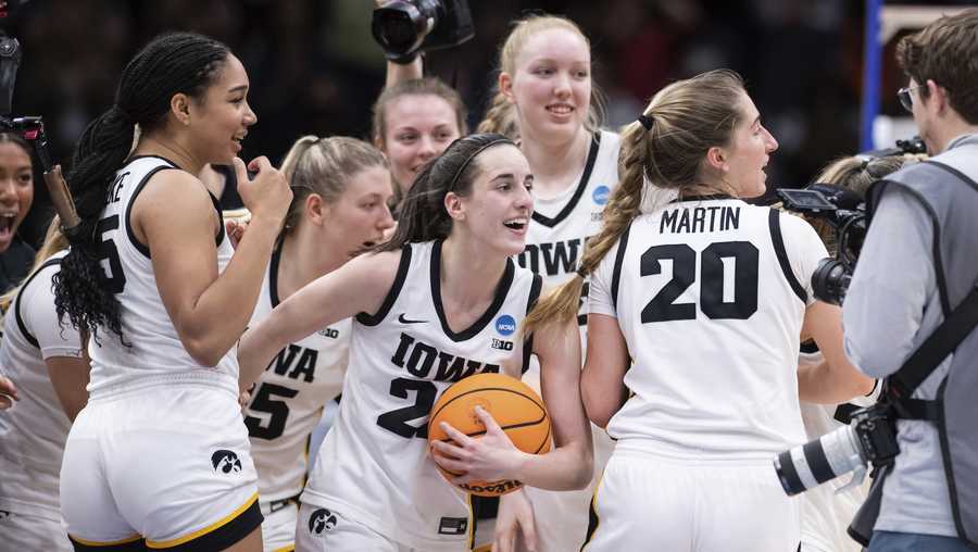 FILE - Iowa players, including guard Caitlin Clark, front center, forward Hannah Stuelke, front left, and guard Kate Martin (20) celebrate after an Elite 8 basketball game of the NCAA Tournament against Louisville, Sunday, March 26, 2023, in Seattle. Clark was honored Thursday, March 30, as The Associated Press women&apos;s college basketball Player of the Year. (AP Photo/Caean Couto, File)